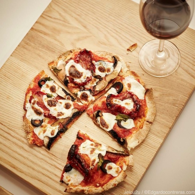 pizza vegetariana con copa de vino